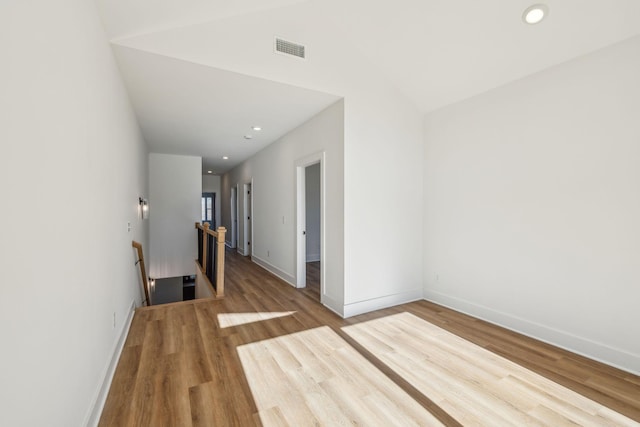 unfurnished room featuring lofted ceiling and hardwood / wood-style flooring