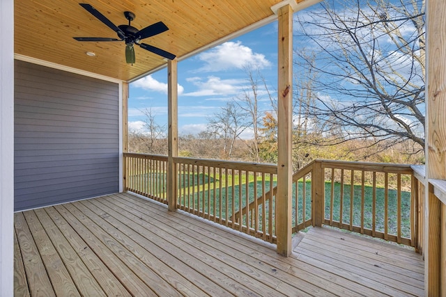 wooden terrace with a lawn and ceiling fan