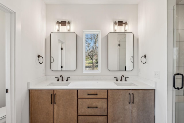 bathroom with vanity, toilet, and a shower with shower door