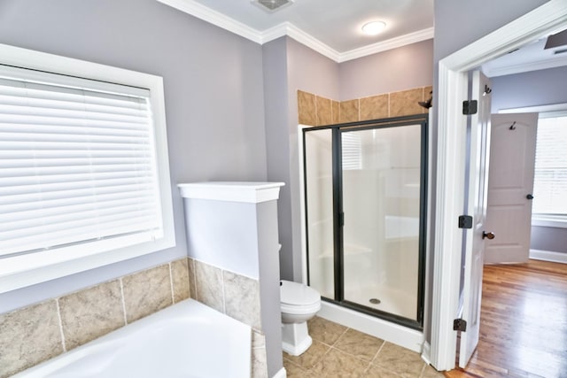 bathroom featuring plus walk in shower, tile patterned floors, toilet, and ornamental molding