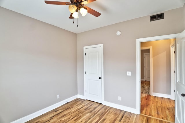 unfurnished bedroom featuring hardwood / wood-style flooring, ceiling fan, and a closet