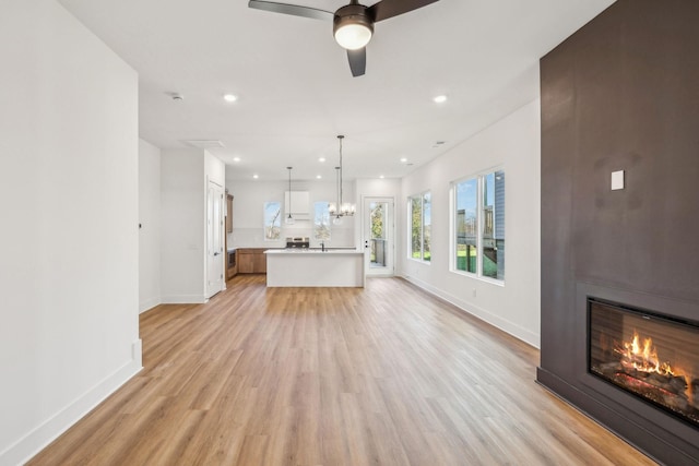 unfurnished living room featuring ceiling fan and light hardwood / wood-style floors