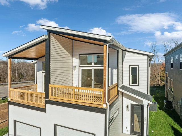 view of property exterior featuring a balcony, a garage, and central air condition unit