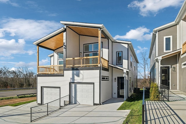 back of property featuring a balcony and a garage