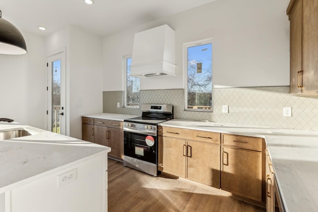 kitchen featuring stainless steel range, sink, dark hardwood / wood-style floors, backsplash, and custom range hood