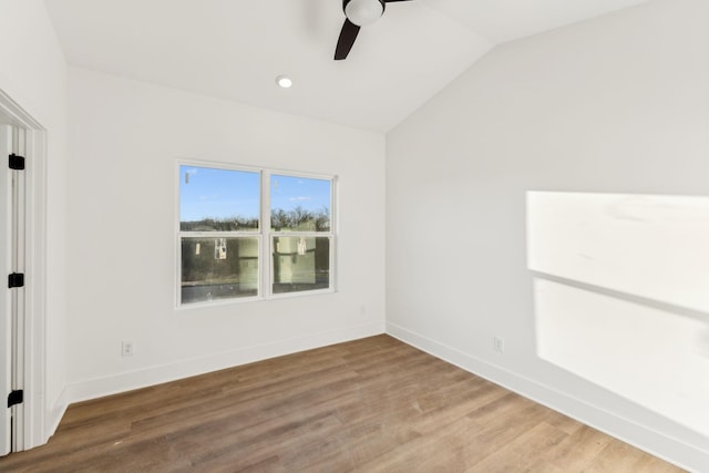 empty room featuring hardwood / wood-style flooring, ceiling fan, and vaulted ceiling