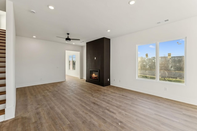 unfurnished living room with a fireplace, light hardwood / wood-style floors, and ceiling fan