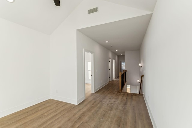 hall with wood-type flooring and lofted ceiling