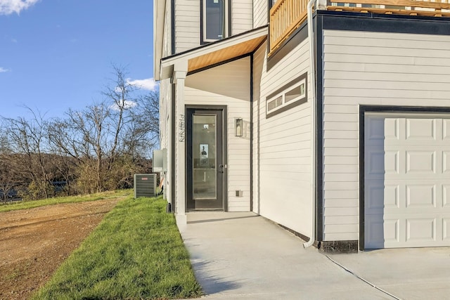 entrance to property featuring a balcony, a garage, and central air condition unit