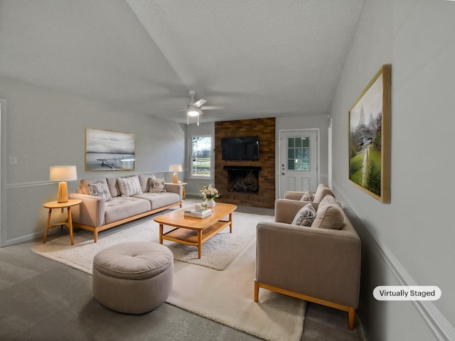 living room with a fireplace, carpet, a textured ceiling, and ceiling fan