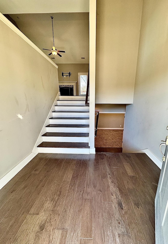 stairs with hardwood / wood-style flooring, ceiling fan, and crown molding