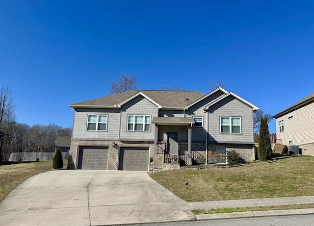 raised ranch with a garage and a front lawn