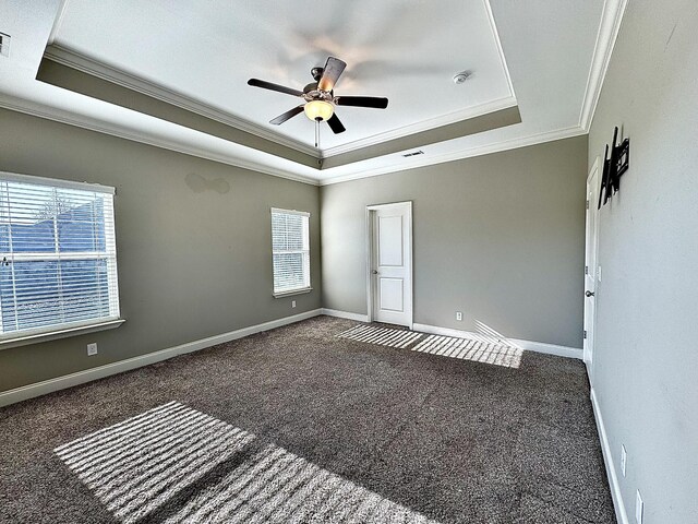 carpeted spare room featuring a raised ceiling, ceiling fan, and crown molding