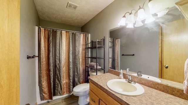 bathroom with vanity, hardwood / wood-style floors, a textured ceiling, and toilet