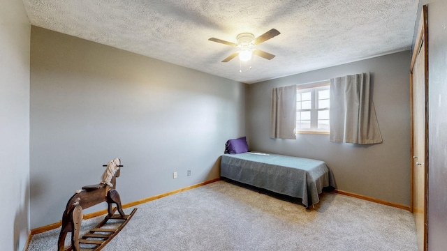 carpeted bedroom with ceiling fan and a textured ceiling