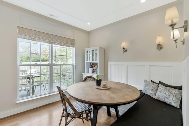 dining room with hardwood / wood-style floors and crown molding