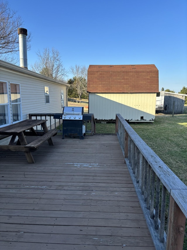 deck with a lawn, grilling area, and a storage shed