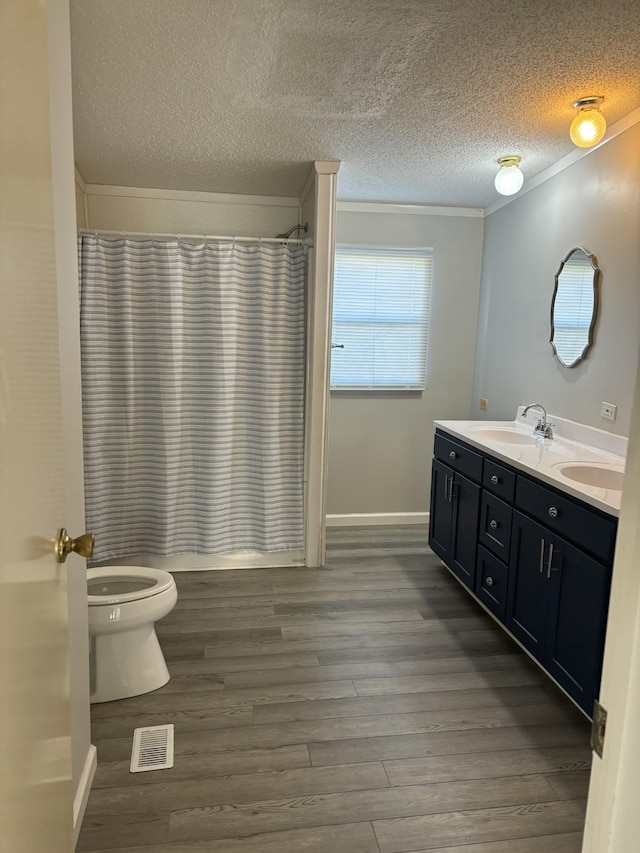 full bathroom with vanity, shower / bath combo, toilet, a textured ceiling, and wood-type flooring