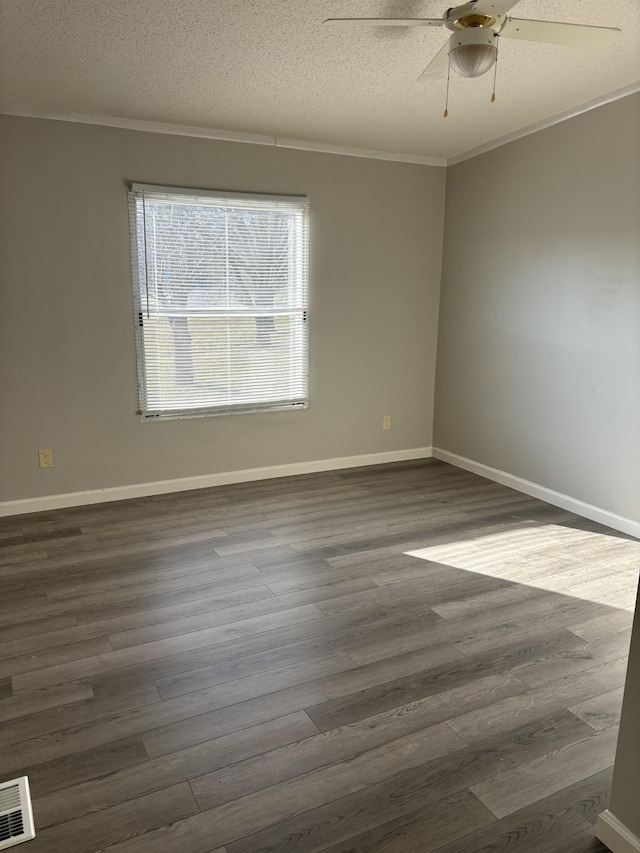 unfurnished room with ceiling fan, crown molding, dark wood-type flooring, and a textured ceiling