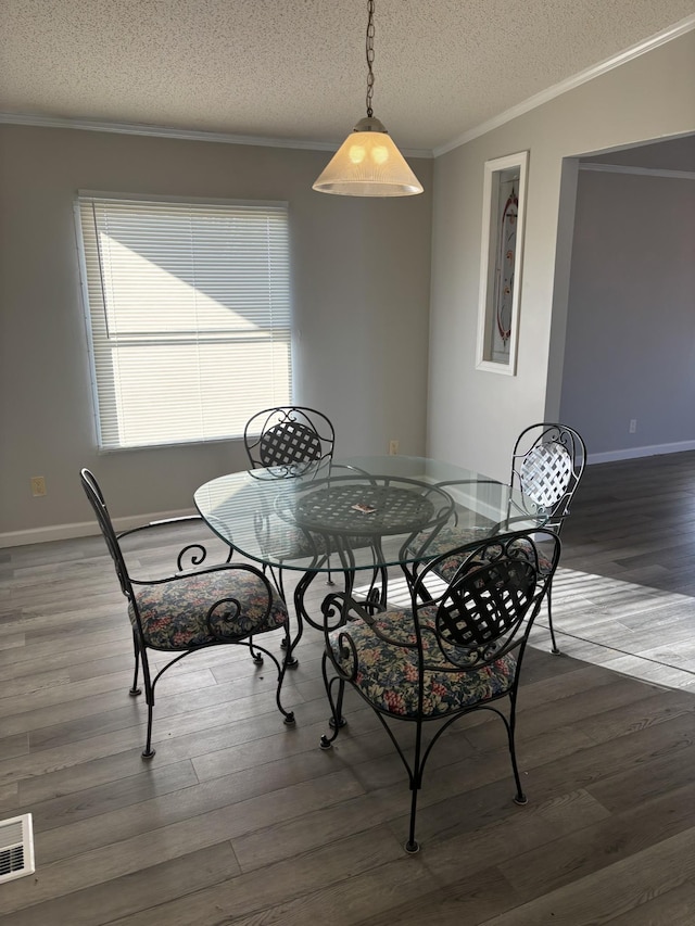 dining room featuring ornamental molding, a textured ceiling, and dark wood-type flooring