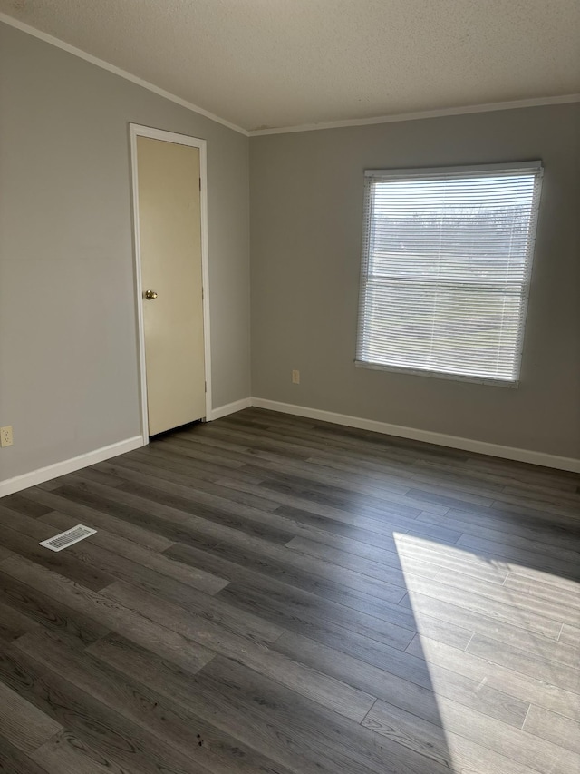 spare room featuring ornamental molding, a textured ceiling, vaulted ceiling, and dark wood-type flooring