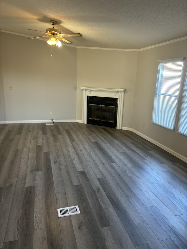 unfurnished living room featuring crown molding, dark hardwood / wood-style flooring, ceiling fan, and a textured ceiling