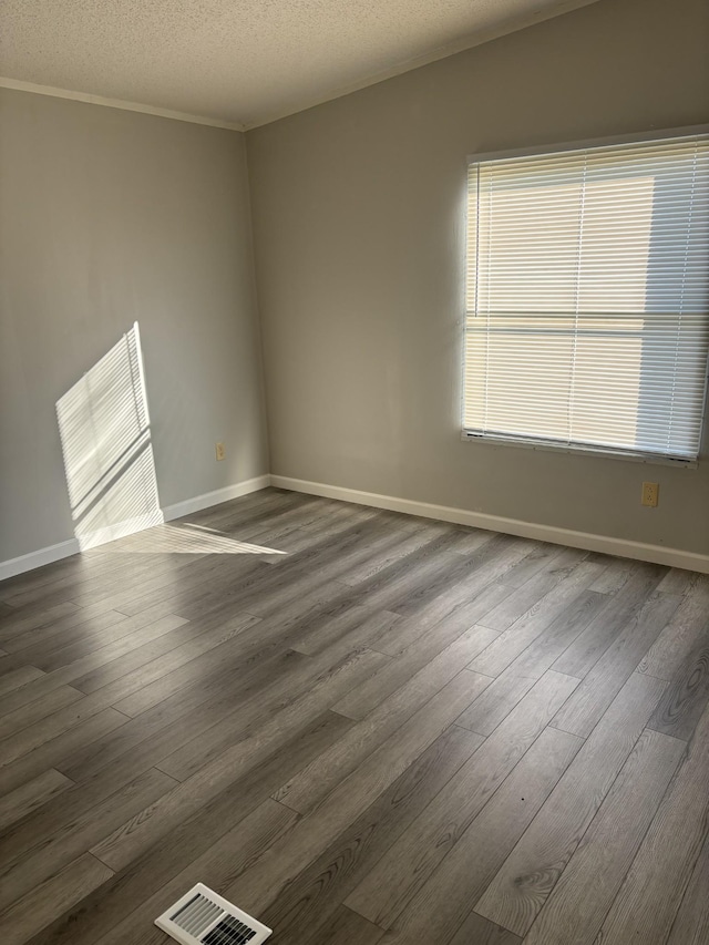 spare room featuring dark hardwood / wood-style floors and a textured ceiling