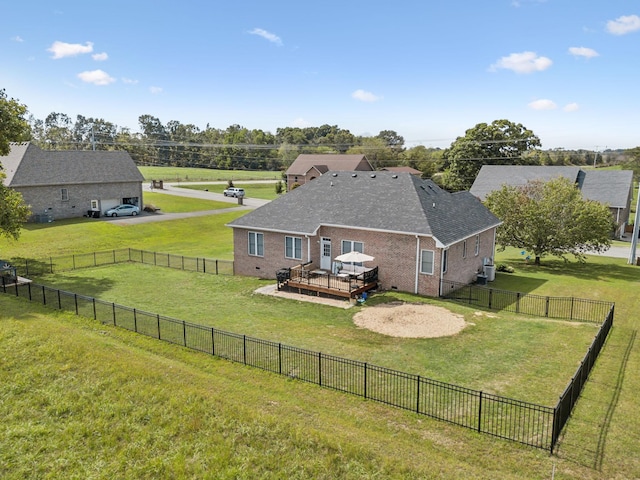 back of house with a wooden deck and a lawn