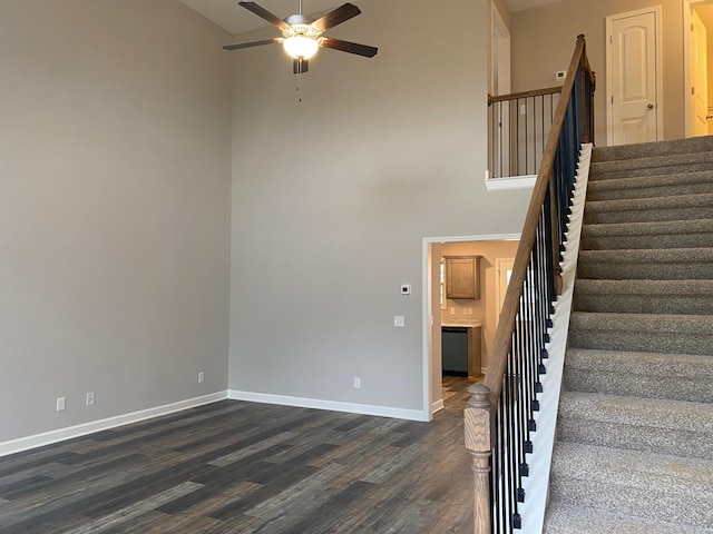 stairway featuring hardwood / wood-style floors, a towering ceiling, and ceiling fan