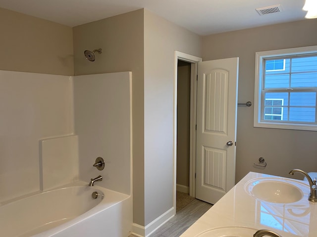 bathroom featuring vanity and  shower combination