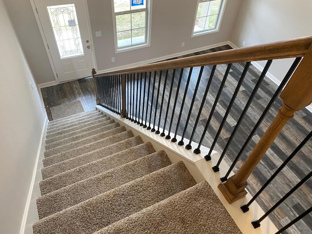 stairway featuring hardwood / wood-style flooring and a healthy amount of sunlight