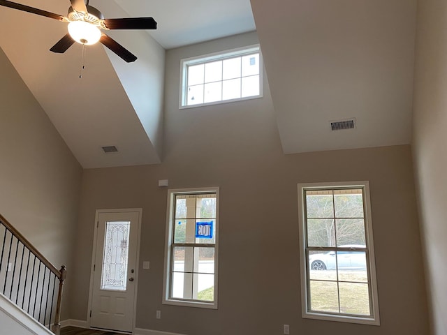 entryway featuring ceiling fan and a towering ceiling