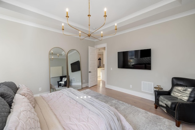 bedroom with crown molding, an inviting chandelier, and light hardwood / wood-style flooring