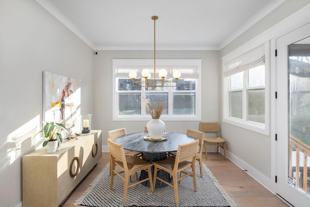 dining room with hardwood / wood-style flooring, ornamental molding, and a notable chandelier