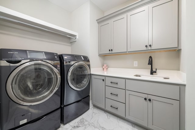 clothes washing area featuring cabinets, sink, and washing machine and clothes dryer