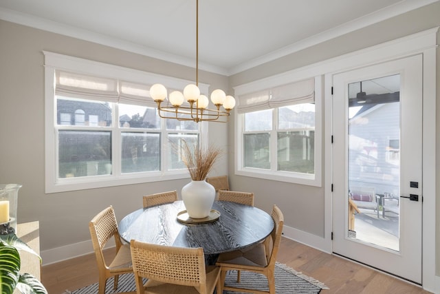 dining space with an inviting chandelier, wood-type flooring, and ornamental molding