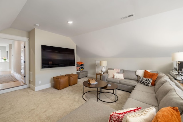 carpeted living room featuring vaulted ceiling