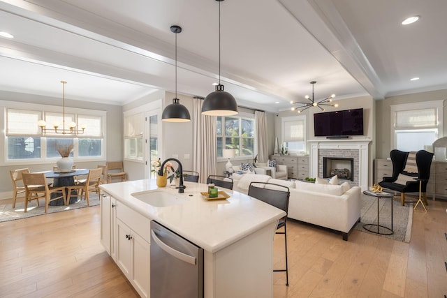 kitchen featuring an inviting chandelier, white cabinetry, an island with sink, and dishwasher