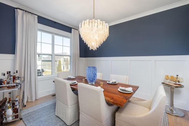 dining room with crown molding, a chandelier, and light wood-type flooring