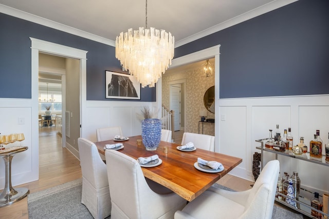 dining room featuring hardwood / wood-style flooring, ornamental molding, and a chandelier