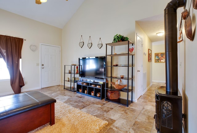 living room with lofted ceiling and a wood stove