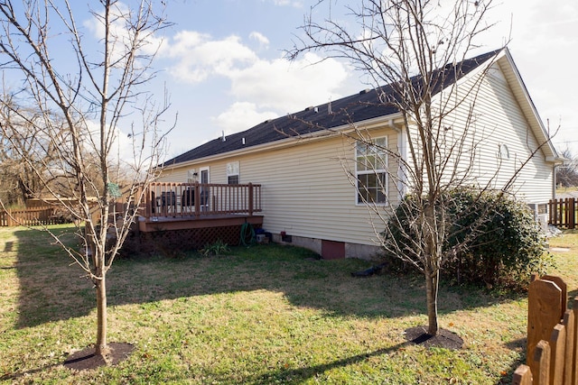 rear view of property with a yard and a deck