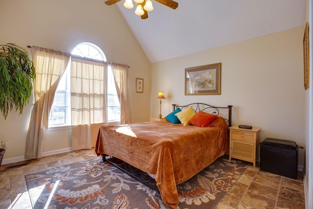 bedroom with ceiling fan and high vaulted ceiling