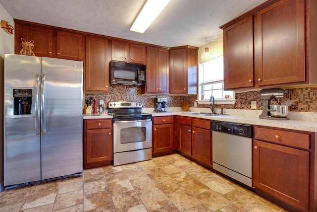 kitchen with backsplash, sink, stainless steel appliances, and a textured ceiling