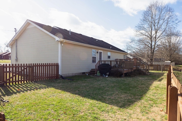 back of house featuring a lawn and a wooden deck