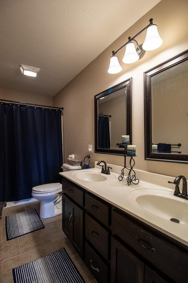 bathroom with vanity, a textured ceiling, and toilet