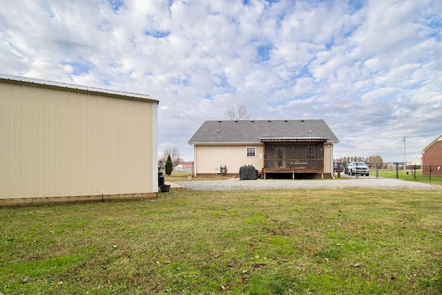 rear view of property with a sunroom and a yard