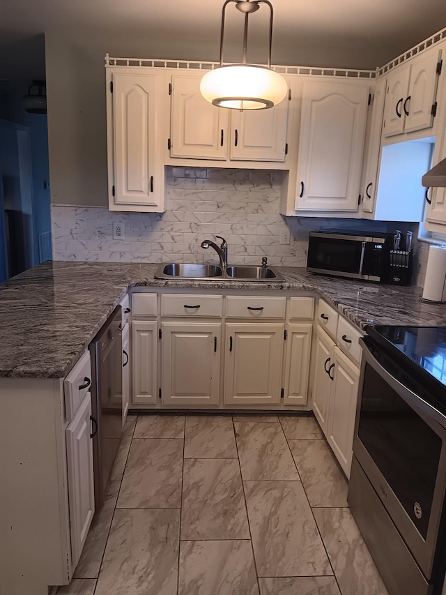 kitchen featuring white cabinetry, sink, appliances with stainless steel finishes, and dark stone counters