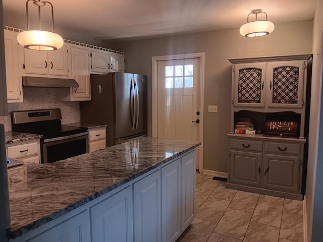 kitchen featuring tasteful backsplash, stainless steel appliances, pendant lighting, dark stone countertops, and white cabinets