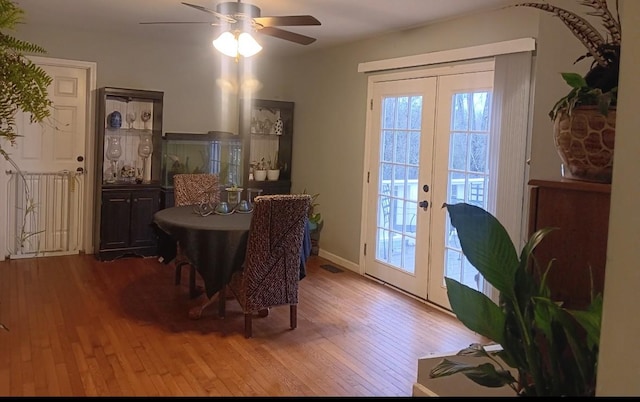 dining room featuring ceiling fan, wood-type flooring, and french doors